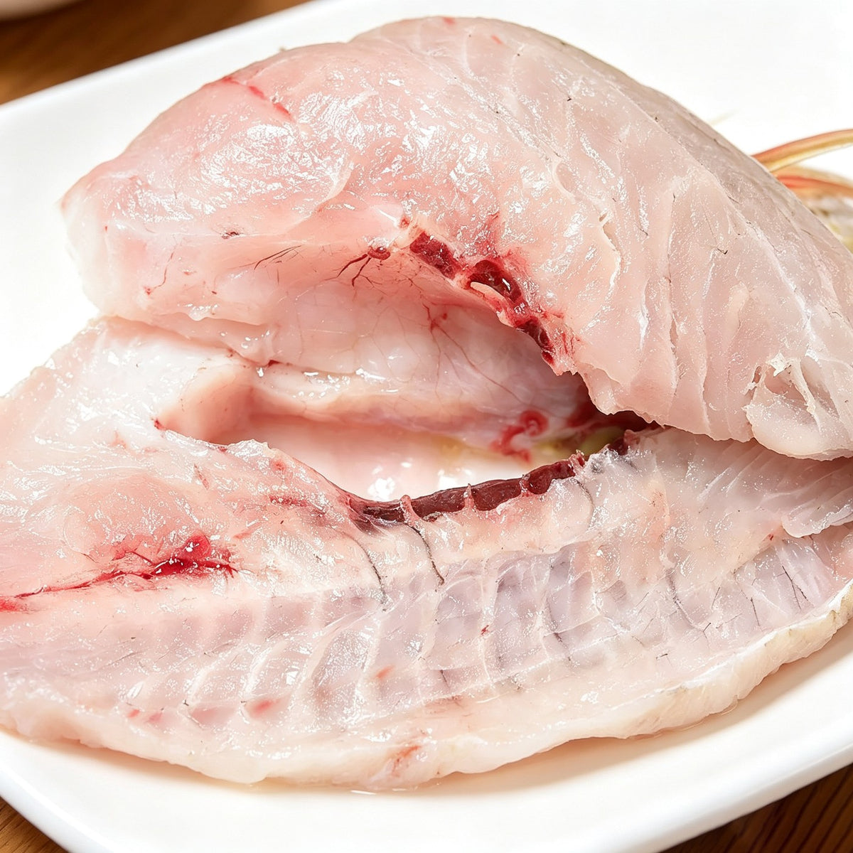 Whole wild-caught sea bream with golden-yellow fins resting on crushed ice