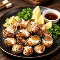 Spotted babylon snails with brown-and-white shells on crushed ice