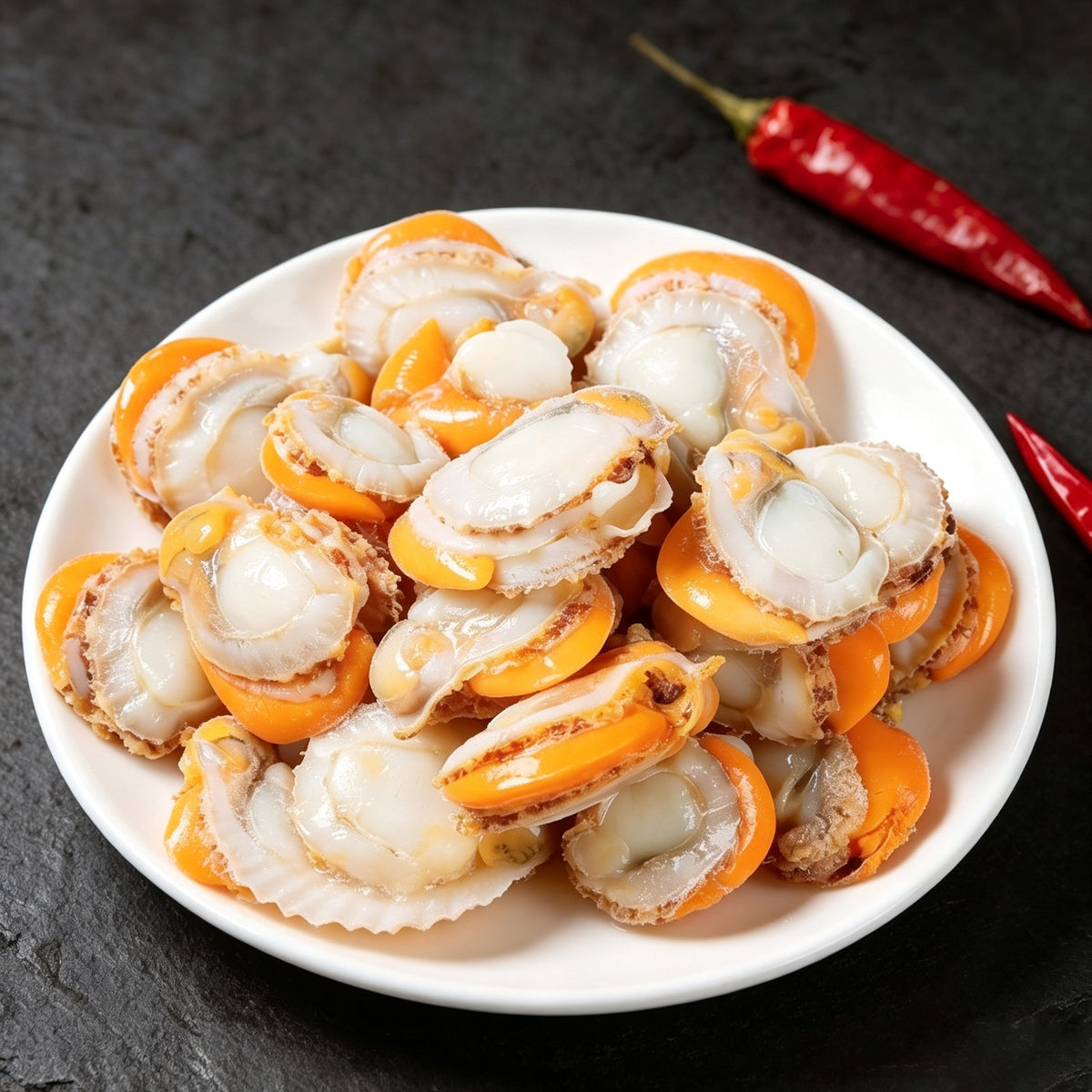Plump white scallops arranged in a ring on a chilled plate (view 3)